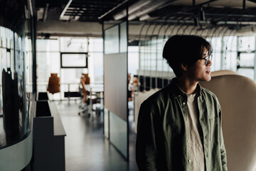 Asian business man walking through modern office space