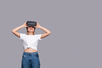 Smile happy woman getting experience using VR-headset glasses of virtual reality isolated over gray...