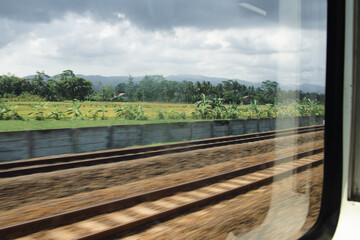 Obraz na płótnie Canvas Beautiful blurred landscape of railroad and nature scenery captured from a train window.