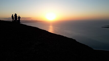 Spain, Lanzarote, Canary island - drone  view of people silhouette  on   amazing sunset in Mirador del Rio on the  Risco de Famara - Tourist looking the sun and the ocean sea - Travel in Lanzarote 