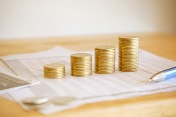 Stack of golden money coin on accounting sheet, pen and credit card. Business and Financial concept. 