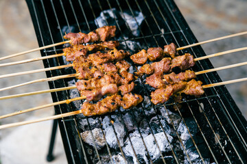 Lamb satay grilled above burnt charcoal.