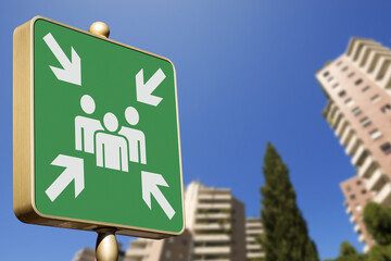 Emergency assembly point. Closeup of a green sign in a city against a clear blue sky. Outdoor sign...