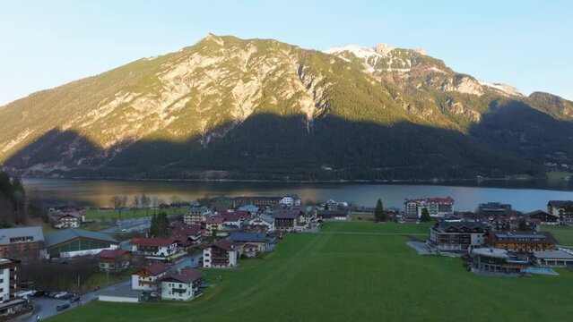 Pertisau Village On The Shore Of Beautiful Achensee Lake During Sunset In Tyrol, Austria - aerial drone shot