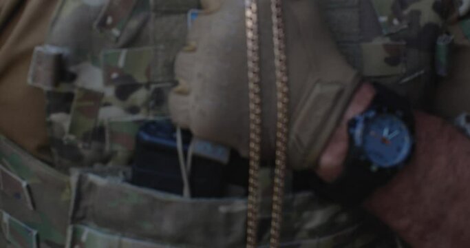  Kyiv, Ukraine, 2022, August,29 � soldier�s hand in tactical glove, holding a badge and a crucifix on a metal chain in his hand, presses it to his chest, to his heart and praying before the battle.