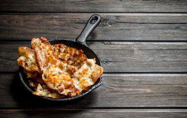 Fried bacon in a frying pan.