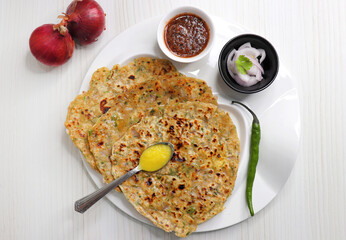 Indian traditional Hot Onion Paratha with tomato chutney. Indian onion stuffed Flatbread. also known as Pyaz ke parathe in Hindi. over a light background with copy space.