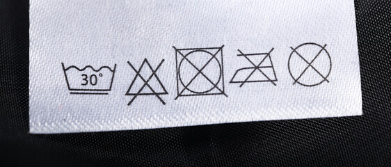 Description of the symbols of washing, ironing on the label of clothes.Label clothes.Wash at 30...