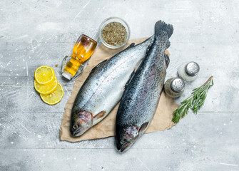 Raw fish salmon with lemon wedges, rosemary and spices.