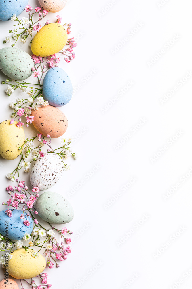 Wall mural easter quail eggs and springtime flowers over white background. spring holidays concept with copy sp