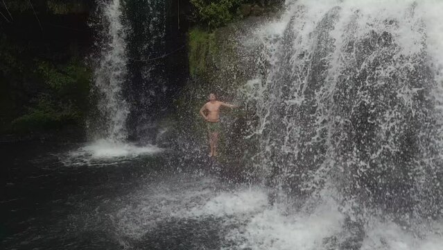 man showers under natural waterfall. Stunning aerial view flight tracking shot from above drone
of thailand jungle khlong chao on island ko kut, dezember 2022. High Quality 4k Cinematic footage