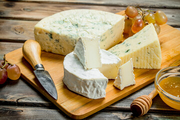 Blue and brie cheese with honey and grape branches.