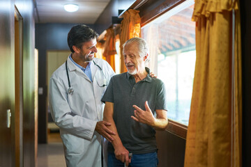 Freundlicher Arzt kümmert sich um Senior mit Krückstock