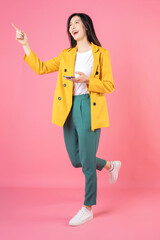 Full length image of young Asian business woman standing on background