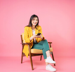 Image of young Asian businesswoman sitting on chair