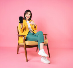 Image of young Asian businesswoman sitting on chair
