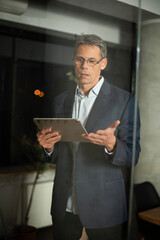 Portrait of successful businessman in office. Man writing on the glass board in office