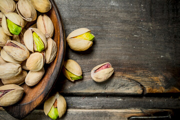 Pistachios in a wooden spoon.