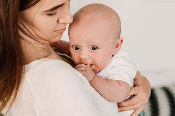 Little boy funny cute child baby, mother hold comforting the child, soothes lulling the crying kid. Playful toddler with bulging eyes, making faces grimaces. Happy childhood, family concept

