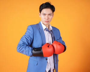 Image of young Asian anger businessman with boxing glove