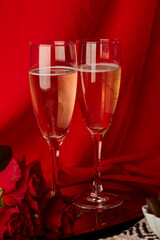 Romantic seasonal Valentine background with roses, champagne glasses, candies. Vertical photo