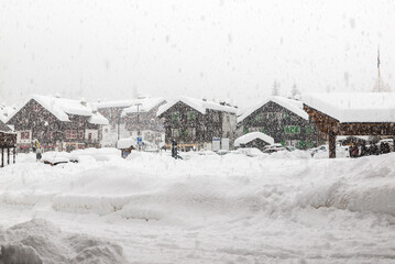 Bad weather and heavy snow in the mountains. Mountain village in winter. Macugnaga, main square,...
