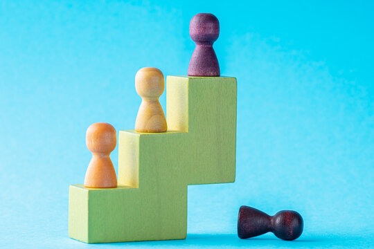 The concept of a leader change. Abstract success building concept. Personal development, personal and career growth, progress and potential. People standing on wood stair.