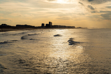 North Sea waves at sunset with Oostende (Ostend) beach and skyline, West Flanders, Belgium.