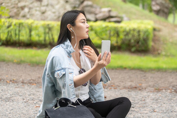 Chinese stylish female using her mobile and taking images