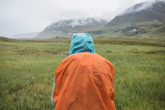 Hiker standing in rain in lush Tj&Atilde;&curren;ktjavagge near S&Atilde;&curren;lka hut, Kungsleden trail, Lapland, Sweden