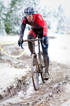 A cyclists races in the mud and snow at a Cyclocross race in Boulder, CO.