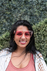 Latin woman with a smile and sunglasses in the city.