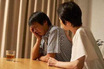 家で落ち込む中年男性