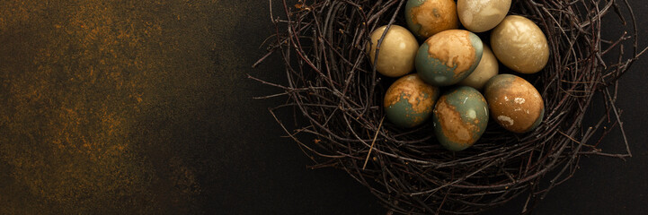 Cosmic Easter eggs in a nest on a brown background, top view, copy space, Easter banner
