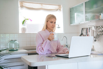 Young attractive blonde girl is working or studying from a home office. Horizontal mockup.