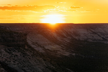 Sun setting behind cliffs in remote desert location during dramatic golden hour