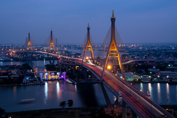 Obraz premium View of Bhumibol Bridge across the Chao Phraya River at night is a landmark of Bangkok and is a cargo road from the port to the city, Thailand.