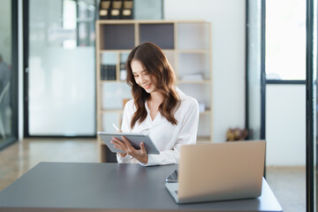 business owner or Asian female marketers are using tablet computer in office work