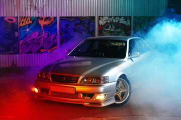 Sport car at the night city street in neon light with smoke