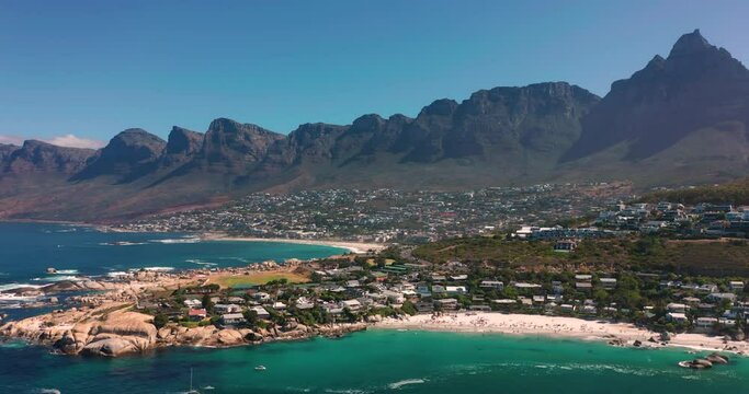 Coastal large city with a harbor on the ocean. Industrial and logistics facilities in the center of the luxury city. Drone view of a growing city in South Africa