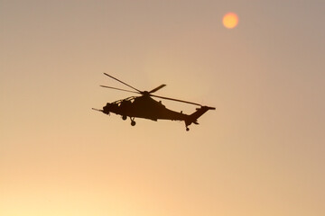 Fototapeta na wymiar military helicopter in the evening sky