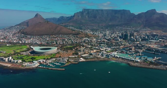 Coastal large city with a harbor on the ocean. Industrial and logistics facilities in the center of the luxury city. Drone view of a growing city in South Africa