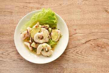 Thai spicy and sour steamed slice squid with lemon salad on plate  