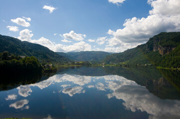 Mountains, clouds and sky reflected in the lake at Norheimsund on the Hardanger fjord, Western Norway.