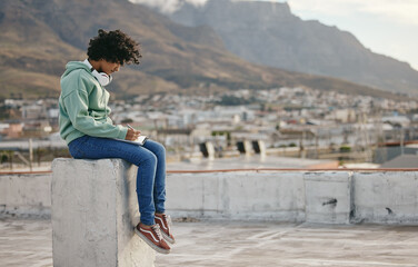 Freedom, book and writing girl on outdoor rooftop for diary inspiration, motivation and peace on Cape town roof building. Pen, notebook and relax for young gen z woman, artist or creative journal