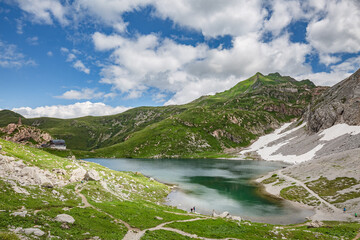 Mountain hiking Trail Road. Small mountain lake. Between Italy and Austria: Volaia Lake Raunchkofer Mountain (Lago di Volaia Monte Rauchkofel)