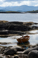 Traditional wooden rowing boat beached on a rocky Island in Norway