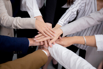 Group of business team harmonious with man and woman joining hands stack together in enterprise for victory and success, teamwork of partnership with meeting and cheering for achievement.