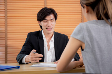 Young woman talking and negotiating about agreement and contract of document with consultant or agent at home office, businessman explaining with client about insurance, two people, business concept.