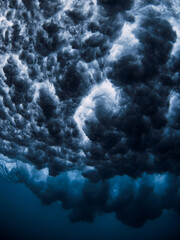 Ocean wave and foam underwater with clear water. Underwater clouds made by powerful wave